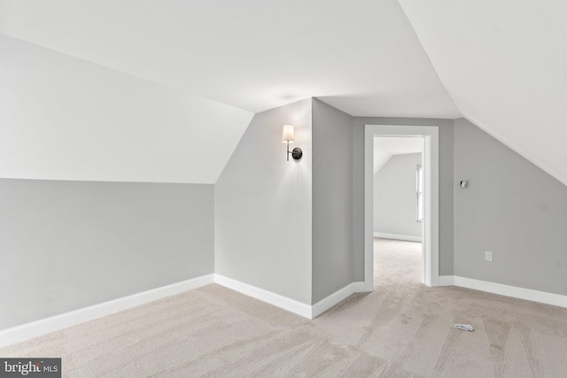 additional living space with light carpet and lofted ceiling