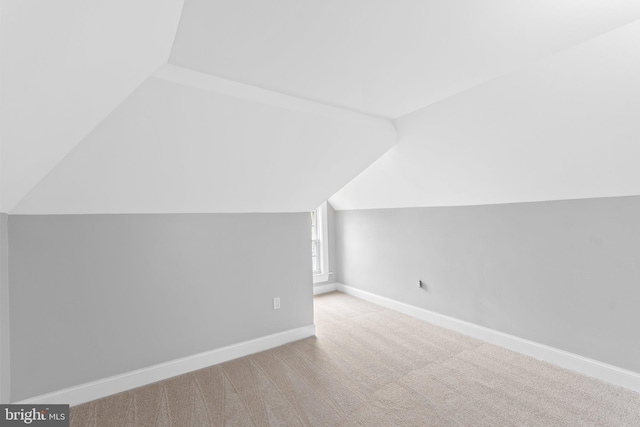 additional living space featuring light carpet and lofted ceiling