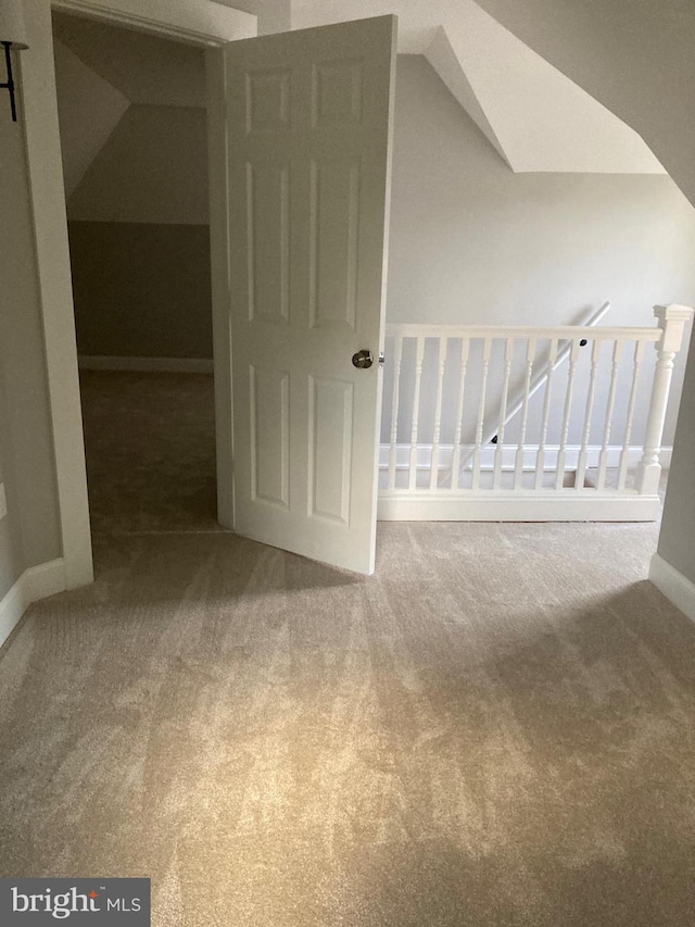 interior space with carpet and vaulted ceiling