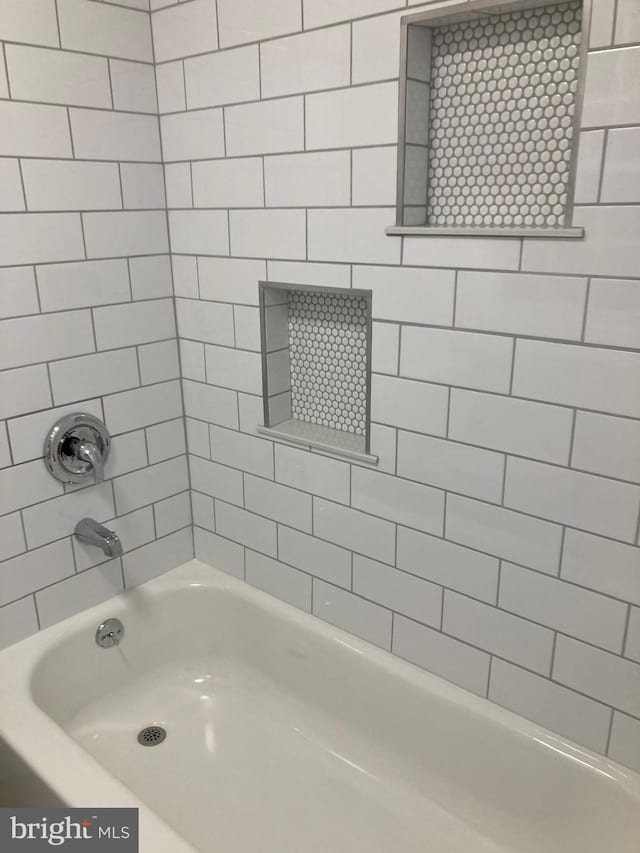 bathroom featuring tiled shower / bath