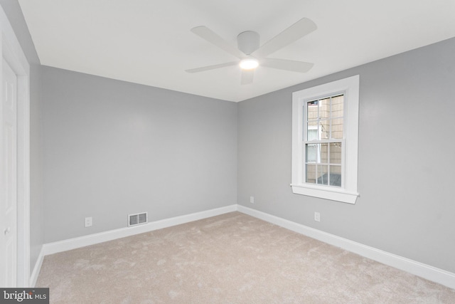 empty room with ceiling fan and light carpet