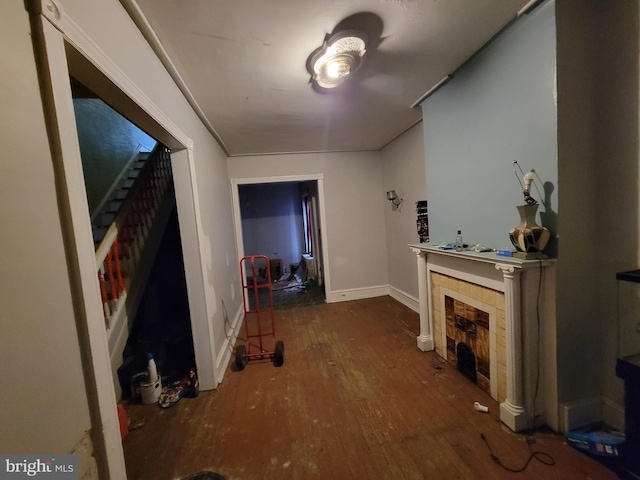 living room featuring a tiled fireplace and hardwood / wood-style floors