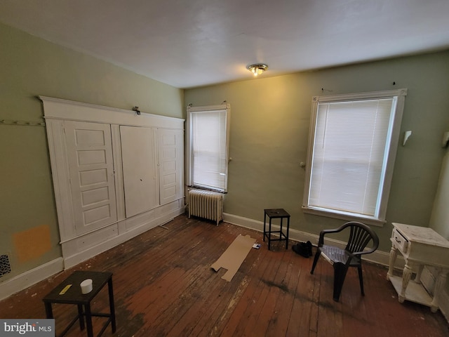 interior space with radiator heating unit and dark hardwood / wood-style floors