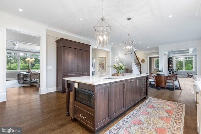 kitchen with dark hardwood / wood-style flooring, sink, black microwave, and ornamental molding