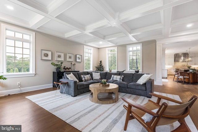 living room with beamed ceiling, coffered ceiling, wood-type flooring, and a notable chandelier