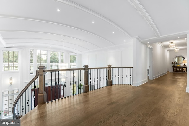 hallway with a chandelier, dark wood-type flooring, and lofted ceiling