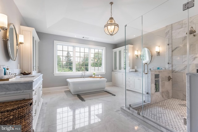 bathroom featuring independent shower and bath, a tray ceiling, tile floors, and vanity