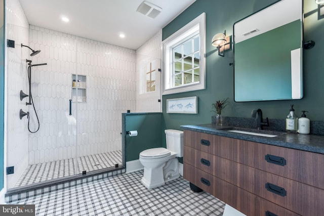 bathroom with tile floors, toilet, walk in shower, and vanity