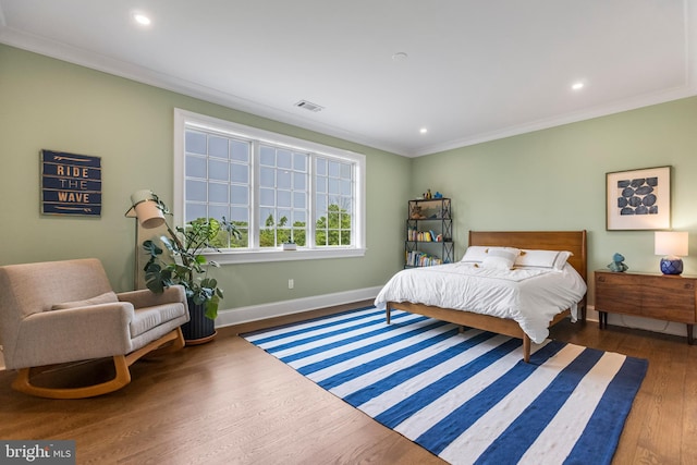 bedroom with crown molding and dark wood-type flooring