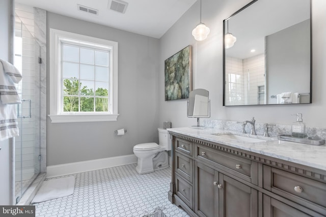 bathroom with tile floors, toilet, vanity, and an enclosed shower