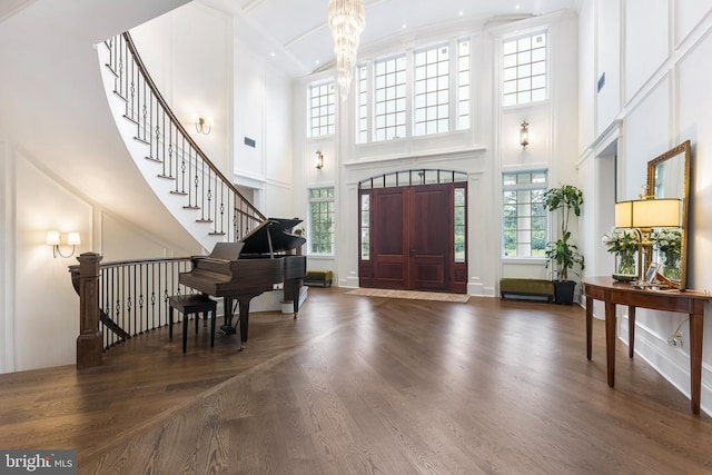 entrance foyer with plenty of natural light, dark hardwood / wood-style flooring, and a towering ceiling