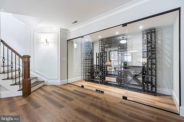 wine cellar featuring crown molding and hardwood / wood-style floors