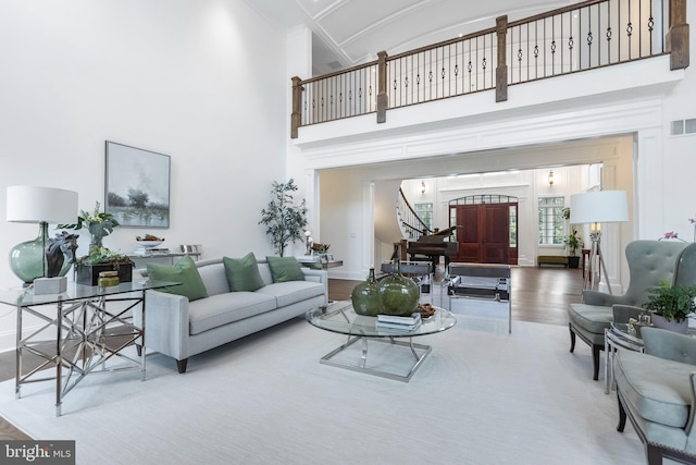 living room with light wood-type flooring and a towering ceiling