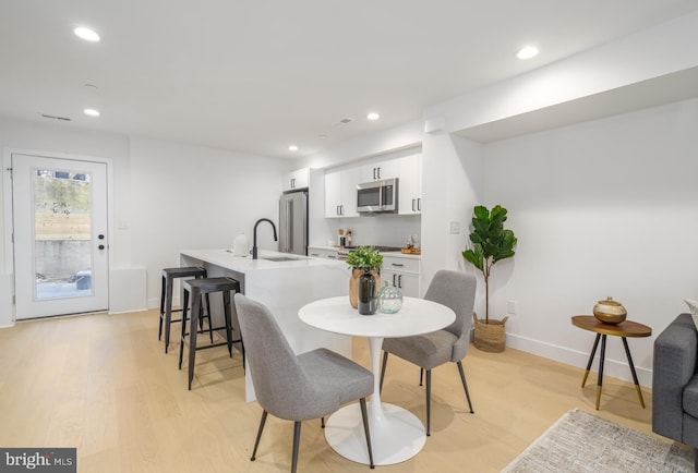 dining space featuring light hardwood / wood-style floors and sink