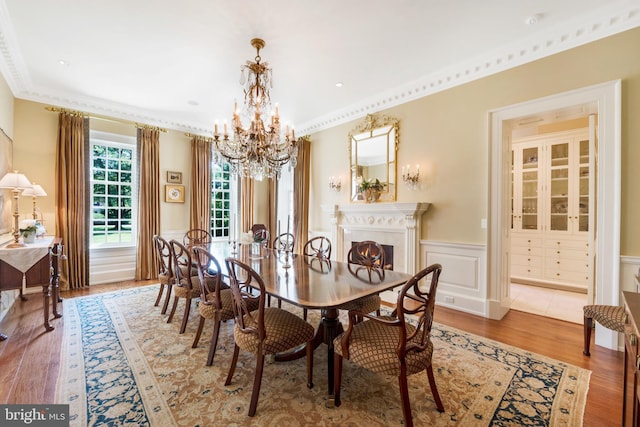 dining space featuring crown molding, a notable chandelier, and hardwood / wood-style flooring