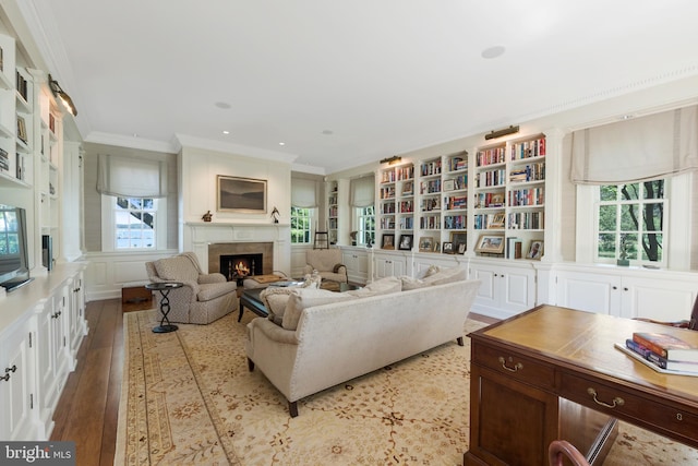 living room featuring light hardwood / wood-style floors, built in features, and crown molding