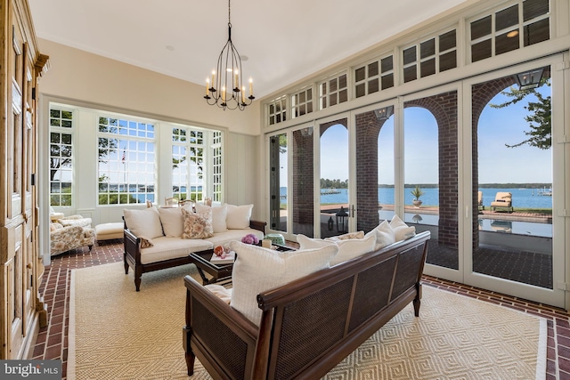 living room featuring a wealth of natural light, a water view, and an inviting chandelier