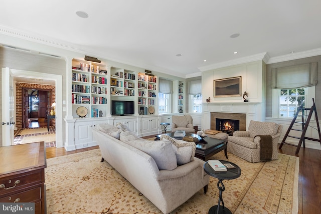 living room with built in features, light hardwood / wood-style flooring, and crown molding