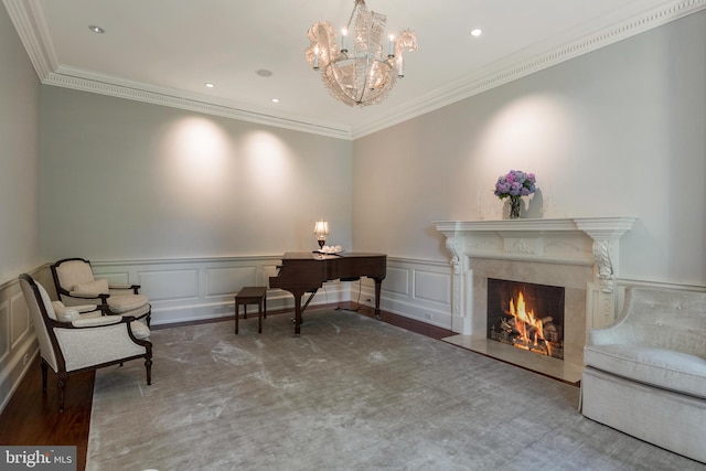 living area featuring a fireplace, an inviting chandelier, hardwood / wood-style floors, and ornamental molding