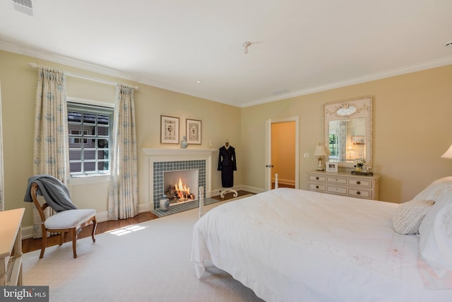 bedroom featuring a fireplace, hardwood / wood-style floors, and ornamental molding