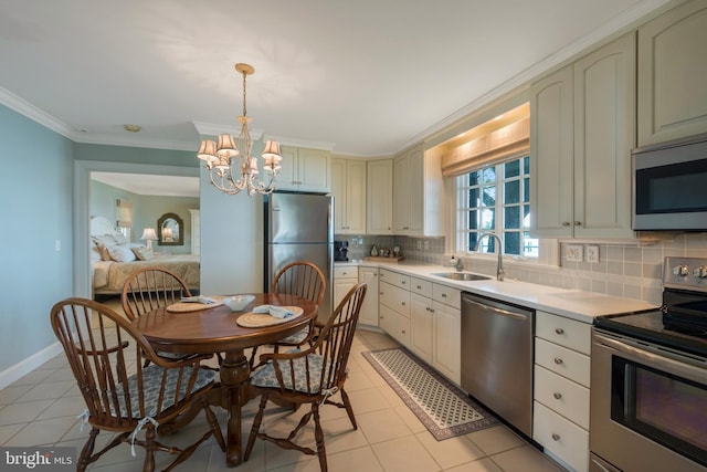 kitchen featuring sink, backsplash, a chandelier, light tile patterned floors, and appliances with stainless steel finishes