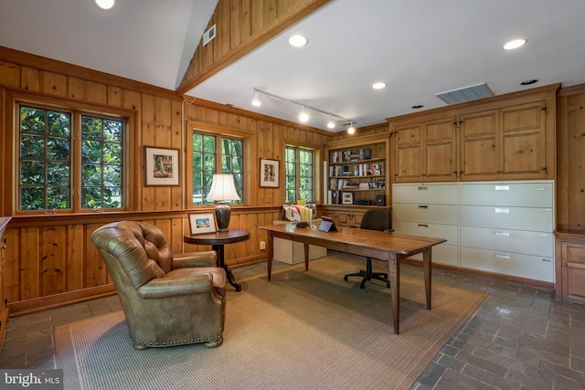 office area with wood walls and lofted ceiling