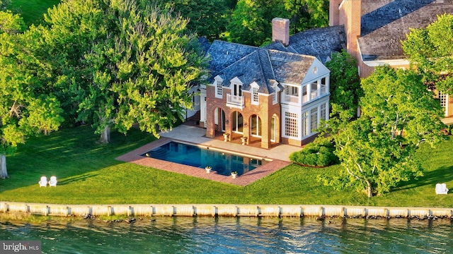 back of house featuring a lawn, a patio area, a balcony, and a water view