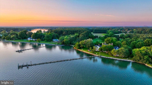 aerial view at dusk featuring a water view