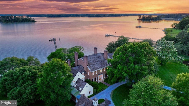 aerial view at dusk featuring a water view