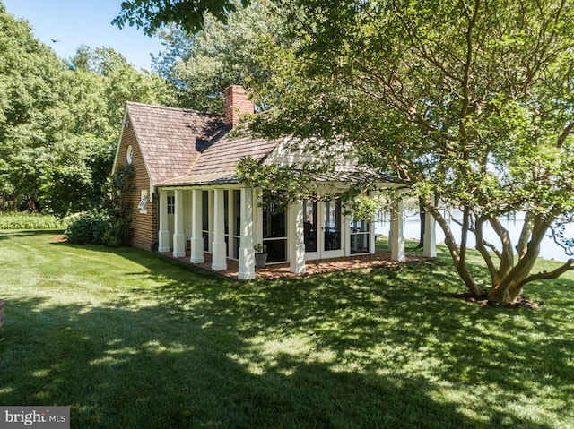 rear view of house featuring a lawn