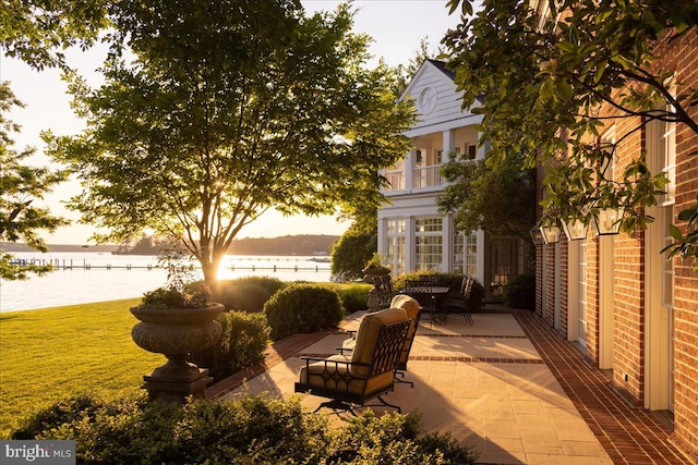 view of patio featuring a water view and a balcony