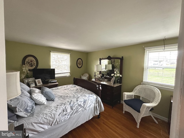 bedroom with multiple windows and dark hardwood / wood-style flooring