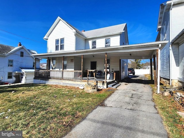 view of front of property featuring a porch, a carport, and a front lawn