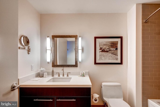 full bathroom featuring tiled shower / bath combo, vanity, and toilet