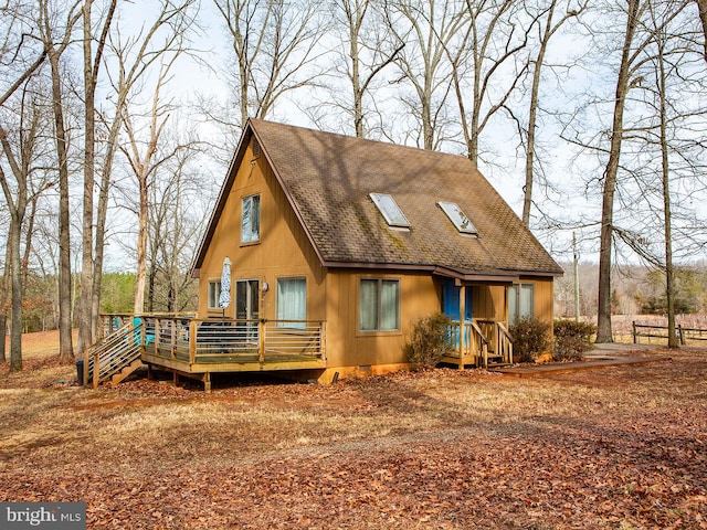 chalet / cabin with crawl space, a deck, and roof with shingles