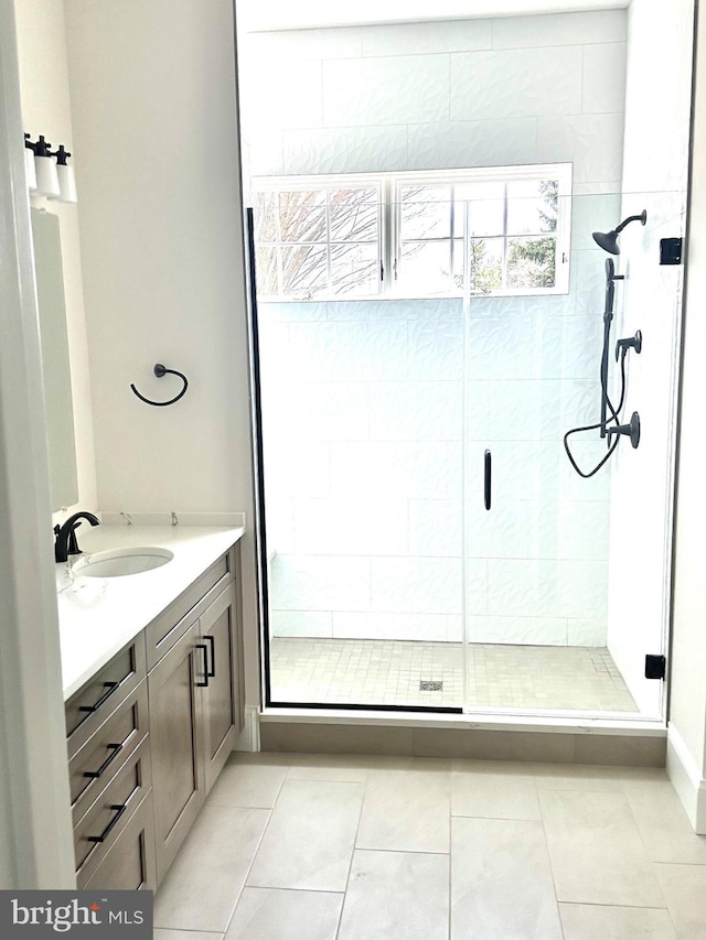 bathroom with tile flooring, vanity, and an enclosed shower