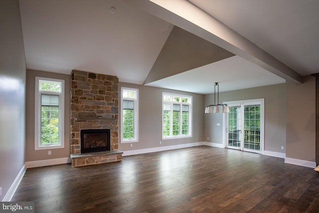 unfurnished living room with a stone fireplace, lofted ceiling, dark hardwood / wood-style floors, and plenty of natural light