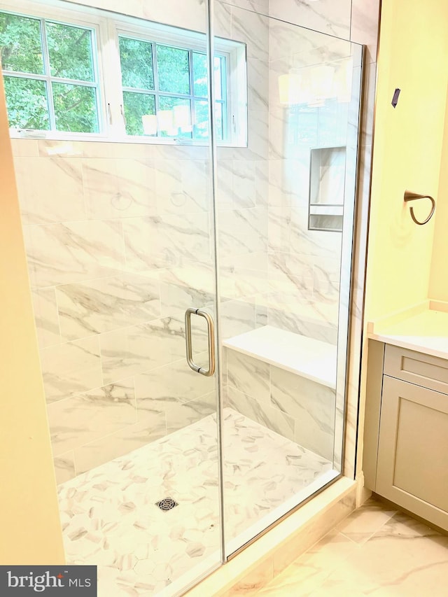 bathroom featuring tile floors, a shower with shower door, and vanity