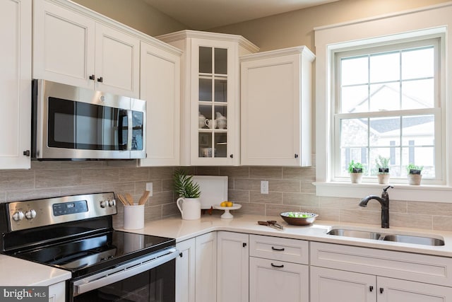 kitchen featuring white cabinets, sink, tasteful backsplash, and stainless steel appliances