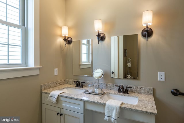 bathroom featuring dual sinks and vanity with extensive cabinet space