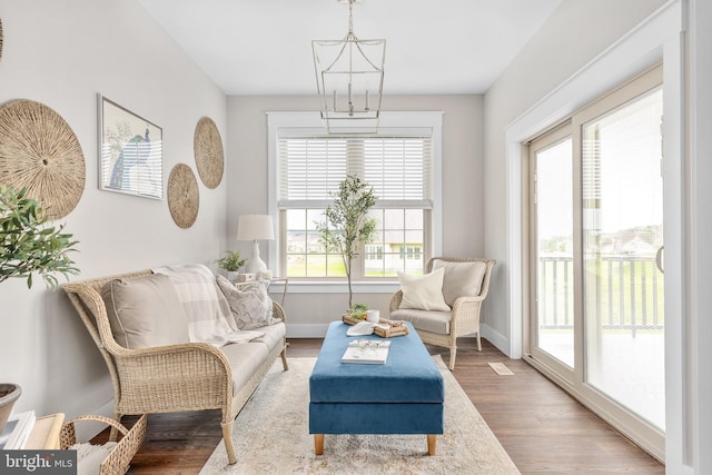 living area with a notable chandelier and hardwood / wood-style flooring