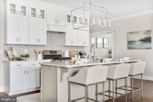 kitchen with stainless steel gas range, white cabinetry, and a breakfast bar