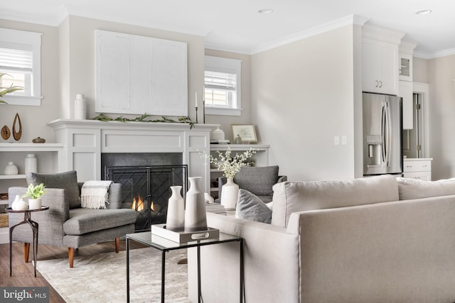 living room with crown molding, a healthy amount of sunlight, and light wood-type flooring