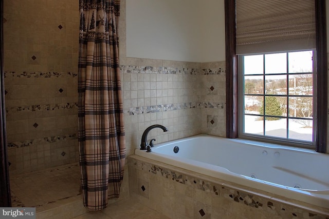 bathroom with a relaxing tiled bath and plenty of natural light