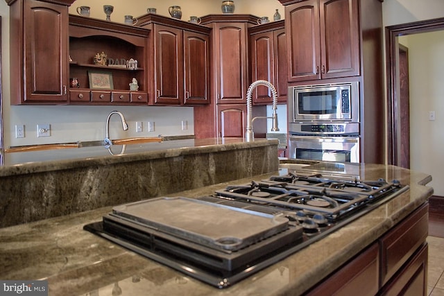 kitchen with appliances with stainless steel finishes and light tile floors