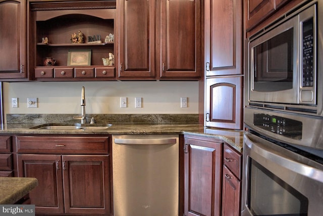 kitchen featuring sink, appliances with stainless steel finishes, and dark stone counters