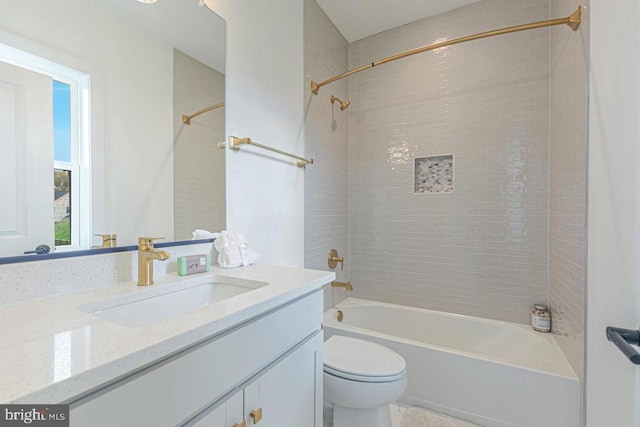 full bathroom featuring tiled shower / bath, toilet, and vanity