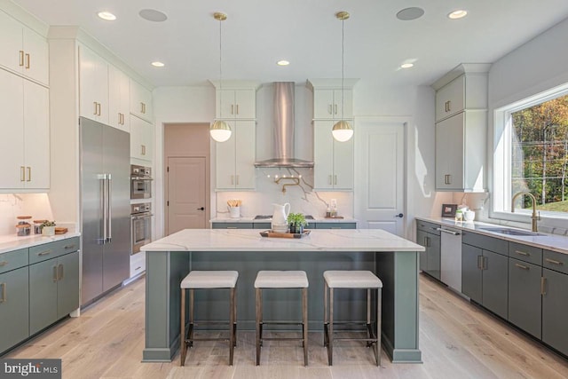 kitchen featuring a breakfast bar, a center island, and wall chimney exhaust hood