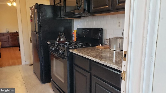 kitchen featuring black range with gas stovetop, decorative backsplash, and light tile patterned floors