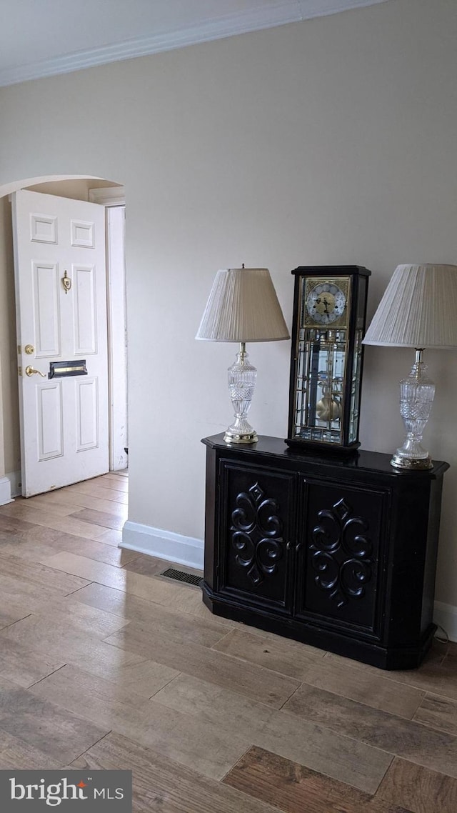 hall with hardwood / wood-style flooring and ornamental molding